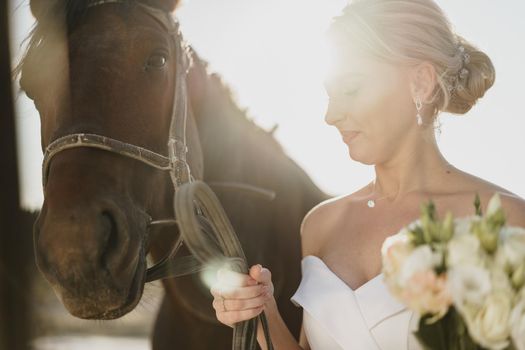 Portrait of a beautiful bride standing with horse