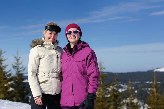 happy friends group of woman girls have fun at winter season at beautiful sunny  snow day with blue sky in background