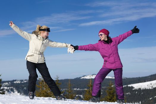 happy friends group of woman girls have fun at winter season at beautiful sunny  snow day with blue sky in background