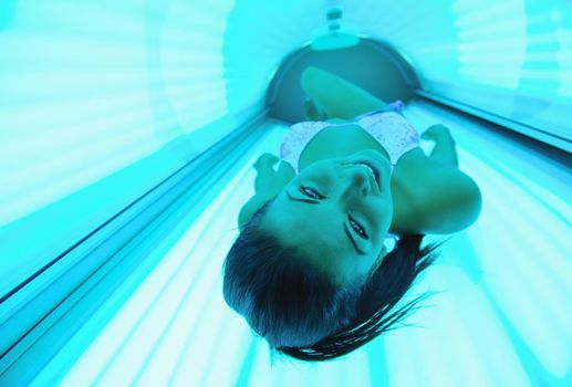 Beautiful young woman have tanning skin treatment in modern solarium