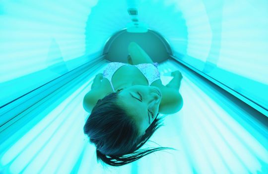 Beautiful young woman have tanning skin treatment in modern solarium