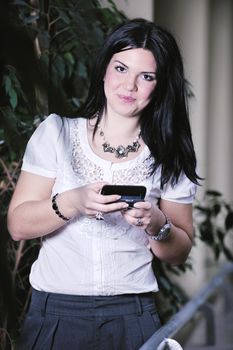 one young happy business woman talking by cellphone indoor in bright building
