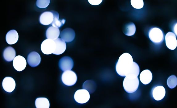 Christmas time and holiday mood concept. Blurred blue xmas tree lights as bokeh background.