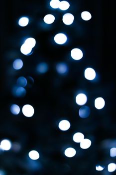 Christmas time and holiday mood concept. Blurred blue xmas tree lights as bokeh background.