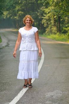 mature aged old senior woman walk and balance on road in fresh nature