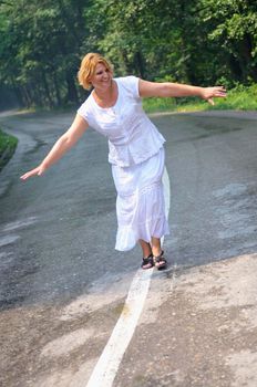 mature aged old senior woman walk and balance on road in fresh nature