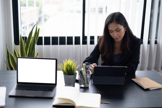 Portrait of cheerful asian woman with casual life on desk in home office. Concept of young business people working at home