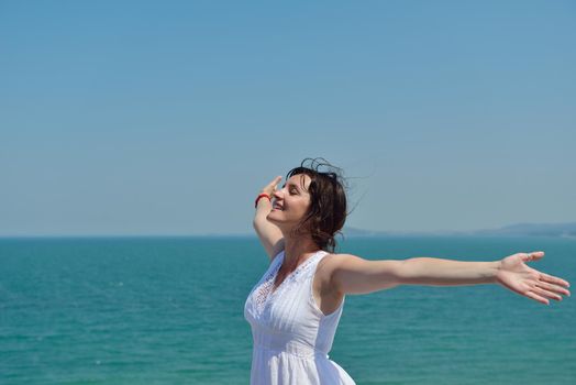Happy  young woman with spreading arms, blue sky with clouds in background  - copyspace