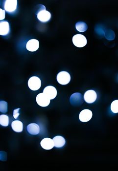 Christmas time and holiday mood concept. Blurred blue xmas tree lights as bokeh background.