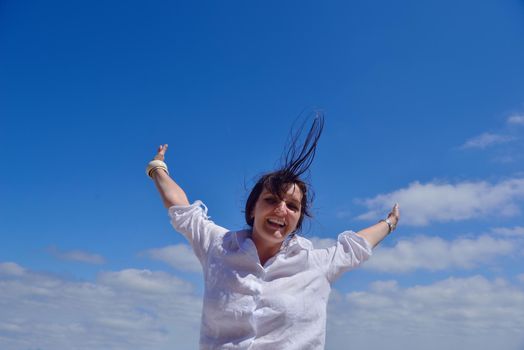 healthy Happy  young woman with spreading arms, blue sky with clouds in background  - copyspace