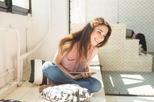 Freelance, blogging and technology concept - young woman using tablet at home.