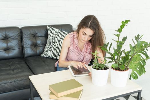 Young woman online shopping using tablet and credit card in livingroom.