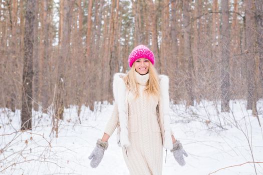 Fun, winter and people concept - Attractive woman dressed in white coat throwing snow