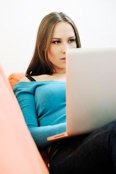 young business woman in casual clothes working on laptop computer on orange sofa isolated on white