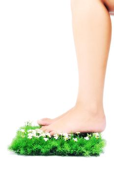 woman legs walking on small peace of green grass isolated on white representing last oasis concept