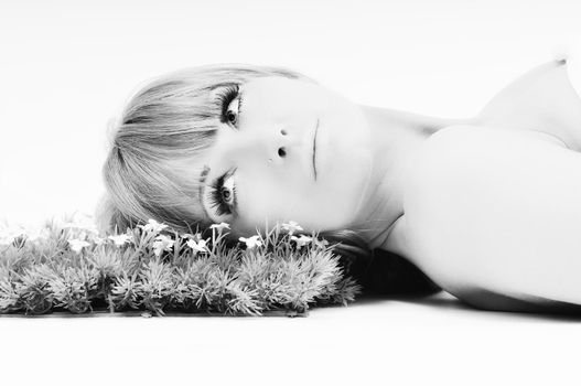 beautiful blonde woman face isolated on white with small green peace of grass