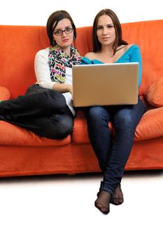 female friends relax and working on  laptop computer at home on orange sofa isolated on white backgrond