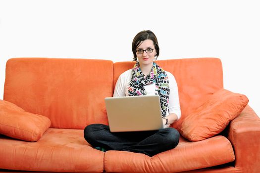 young business woman in casual clothes working on laptop computer on orange sofa isolated on white