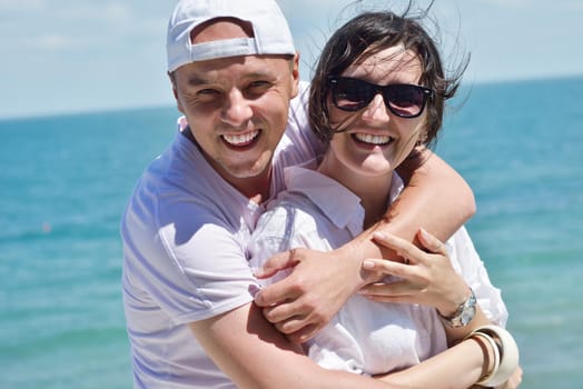 Smiling happy couple looking at camera together at summer beach