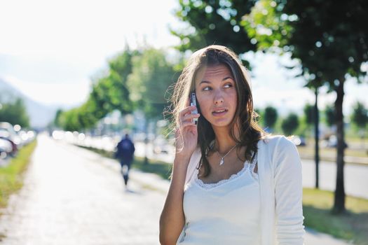 beautiful fit young woman talk by cellphone in city at street on sunny day