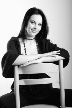 one young beautiful brunette  woman in black posing in studio