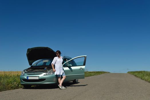 portrait of young beautiful woman with broken car outdoor