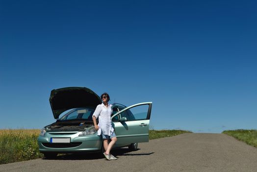 portrait of young beautiful woman with broken car outdoor