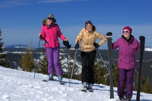 happy friends group of woman girls have fun at winter season at beautiful sunny  snow day with blue sky in background