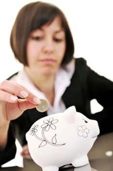 happy young business woman isolated on white puting euro money in piggy bank