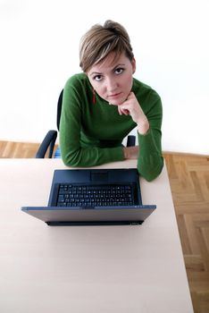 businesswoman in green working on laptop