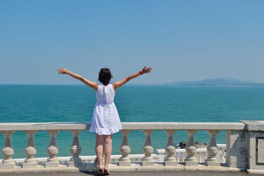 Happy  young woman with spreading arms, blue sky with clouds in background  - copyspace