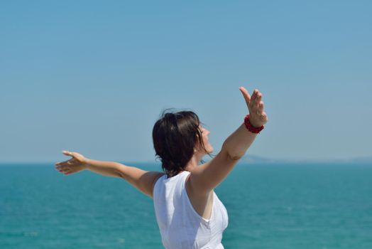 Happy  young woman with spreading arms, blue sky with clouds in background  - copyspace