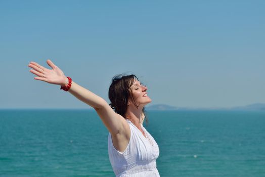 Happy  young woman with spreading arms, blue sky with clouds in background  - copyspace