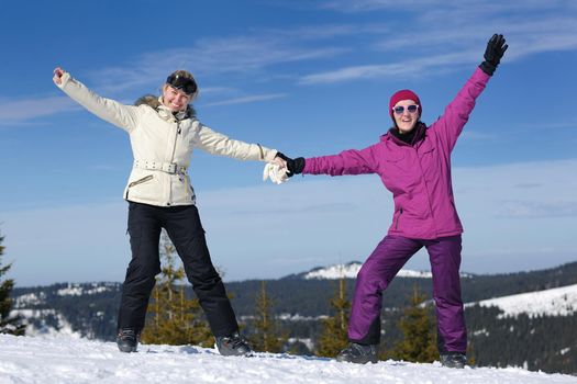 happy friends group of woman girls have fun at winter season at beautiful sunny  snow day with blue sky in background