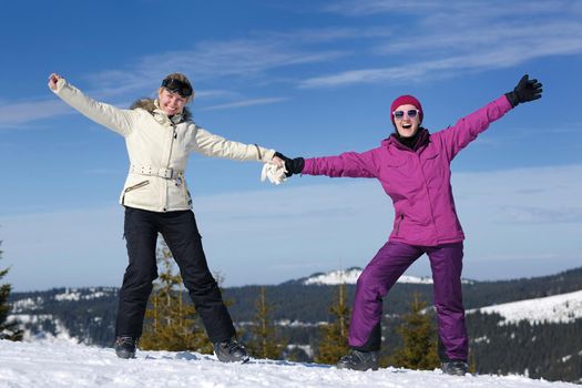 happy friends group of woman girls have fun at winter season at beautiful sunny  snow day with blue sky in background