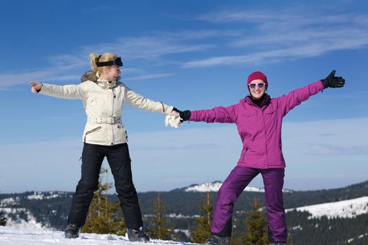 happy friends group of woman girls have fun at winter season at beautiful sunny  snow day with blue sky in background