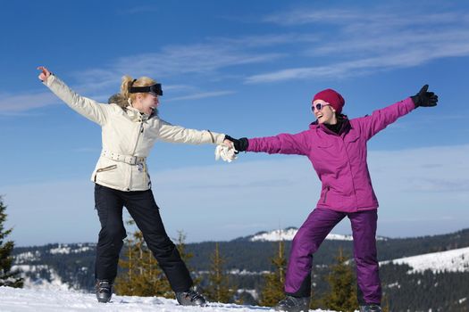 happy friends group of woman girls have fun at winter season at beautiful sunny  snow day with blue sky in background