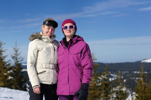 happy friends group of woman girls have fun at winter season at beautiful sunny  snow day with blue sky in background