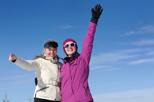 happy friends group of woman girls have fun at winter season at beautiful sunny  snow day with blue sky in background