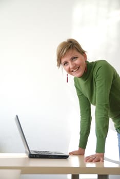 business woman in green standing in office