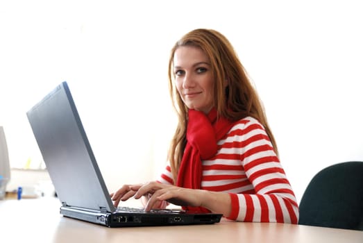 woman in red working on laptop at bright  office