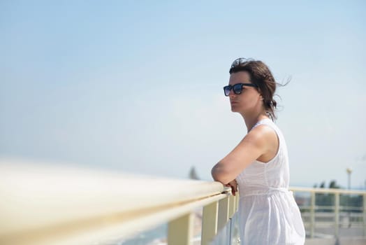 happy young tourist woman have fun while traveling araund city with blue sky and sea in background