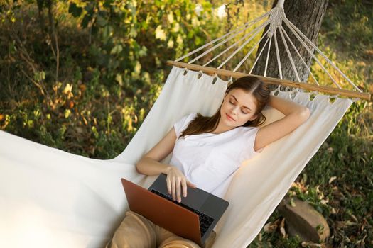 woman lies on a hammock with laptop travel vacation internet. High quality photo