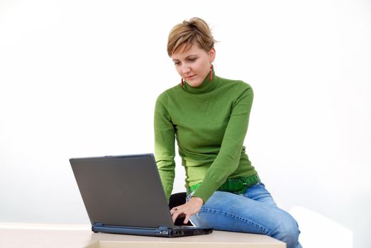 businesswoman in green working on laptop