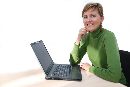 businesswoman in green working on laptop