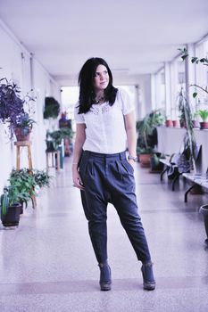 young happy business woman or student posing in fashionable clothes indoor in bright building 