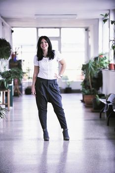 young happy business woman or student posing in fashionable clothes indoor in bright building 