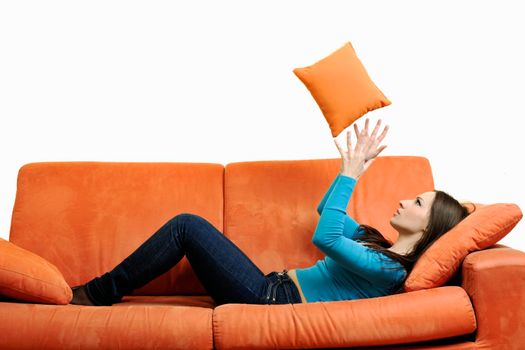 happy young woman relax on orange sofa isolated on white in studio