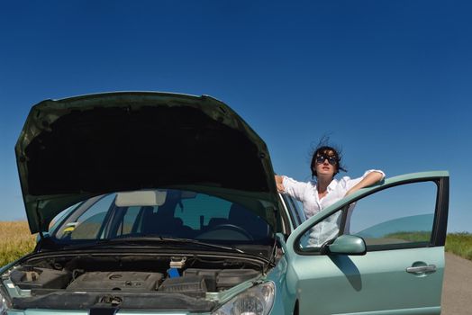 portrait of young beautiful woman with broken car outdoor