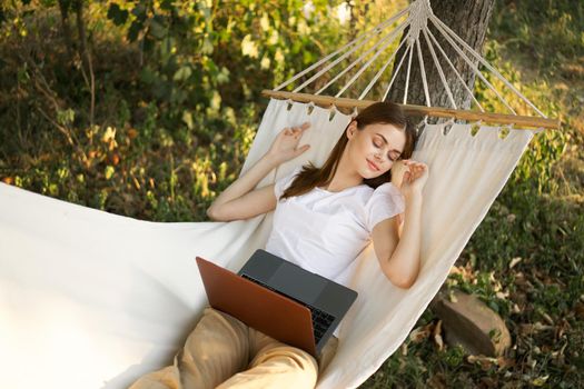 woman lies on a hammock with laptop travel vacation internet. High quality photo